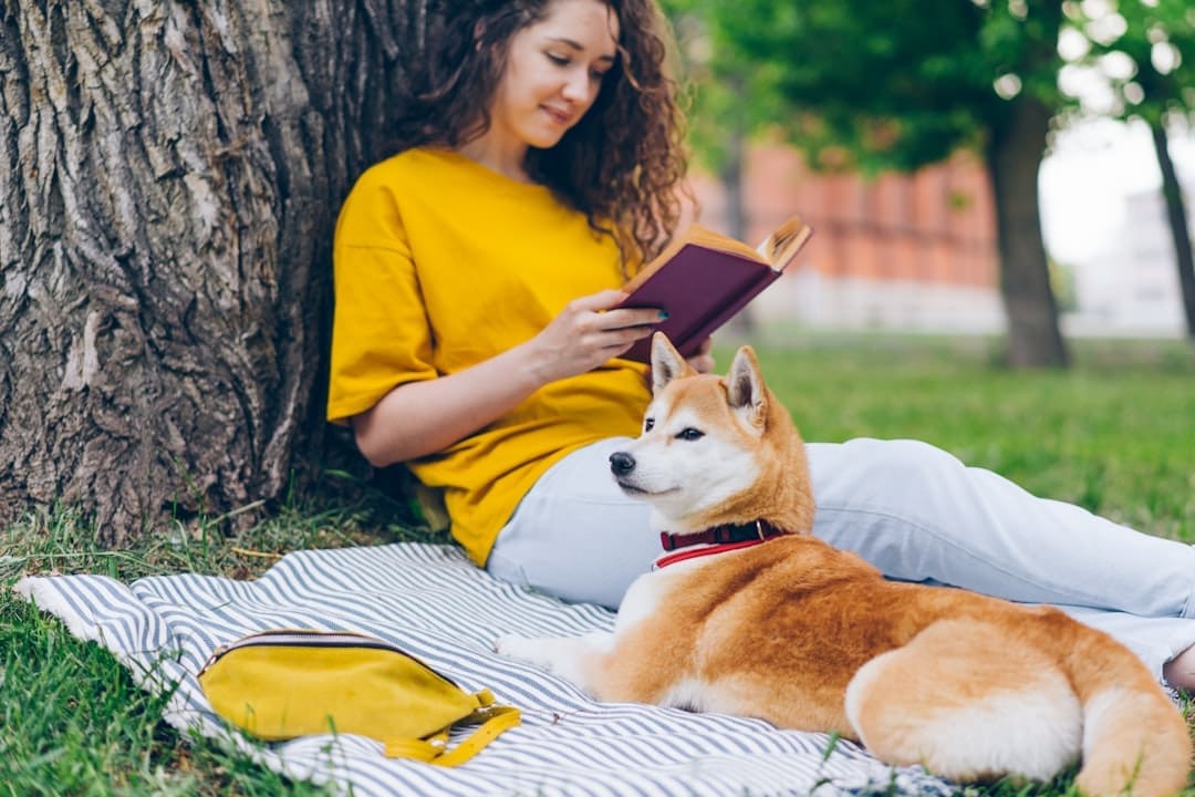 service dog public access — a woman reading a book next to a dog
