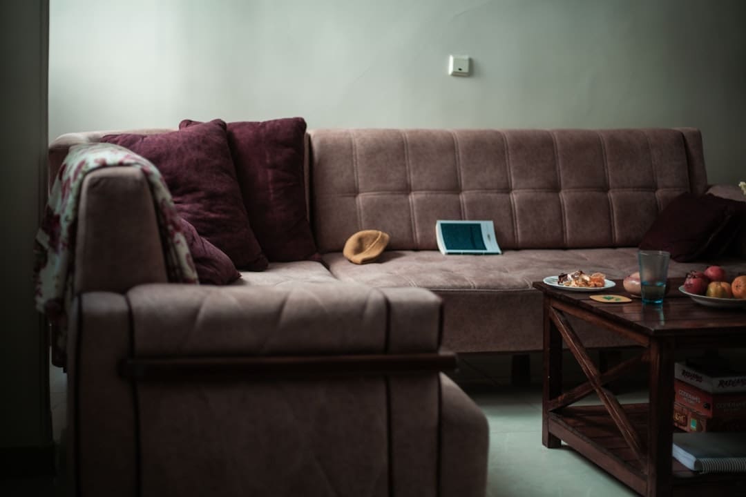 landlord questions — A sectional sofa with pillows and a tablet on it.