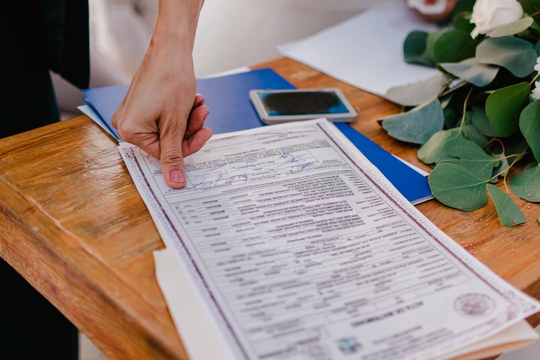 support animal laws — Person pointing at a marriage certificate on a wooden table.