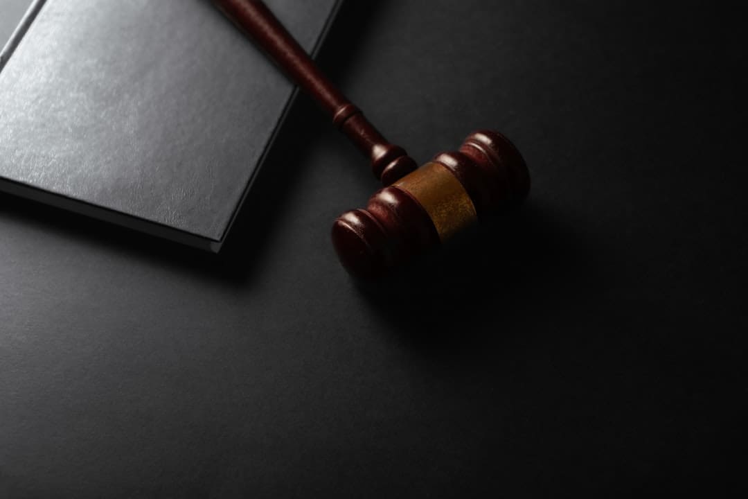 support animal laws — Wooden gavel resting on a dark surface next to book