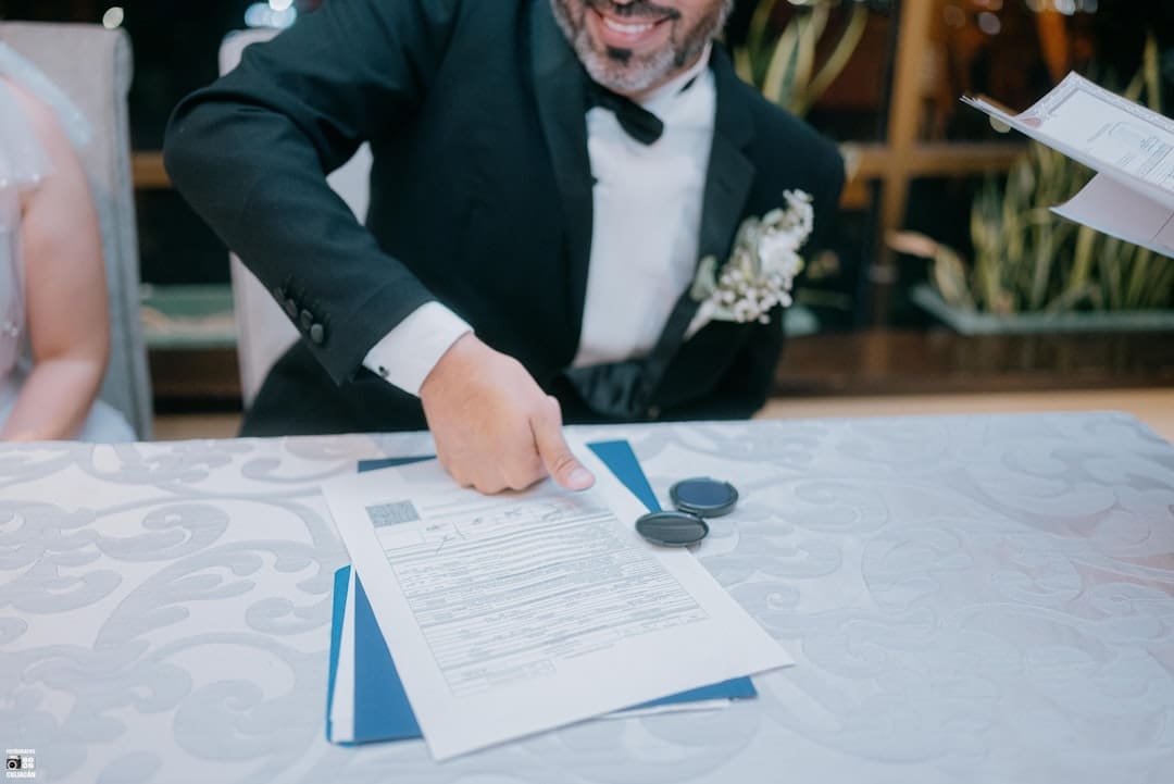 support animal laws — Groom in tuxedo signing wedding documents with a smile.