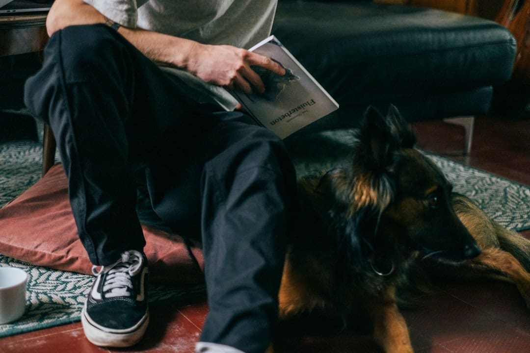 support animal letter — a man sitting on the floor reading a book with his dog