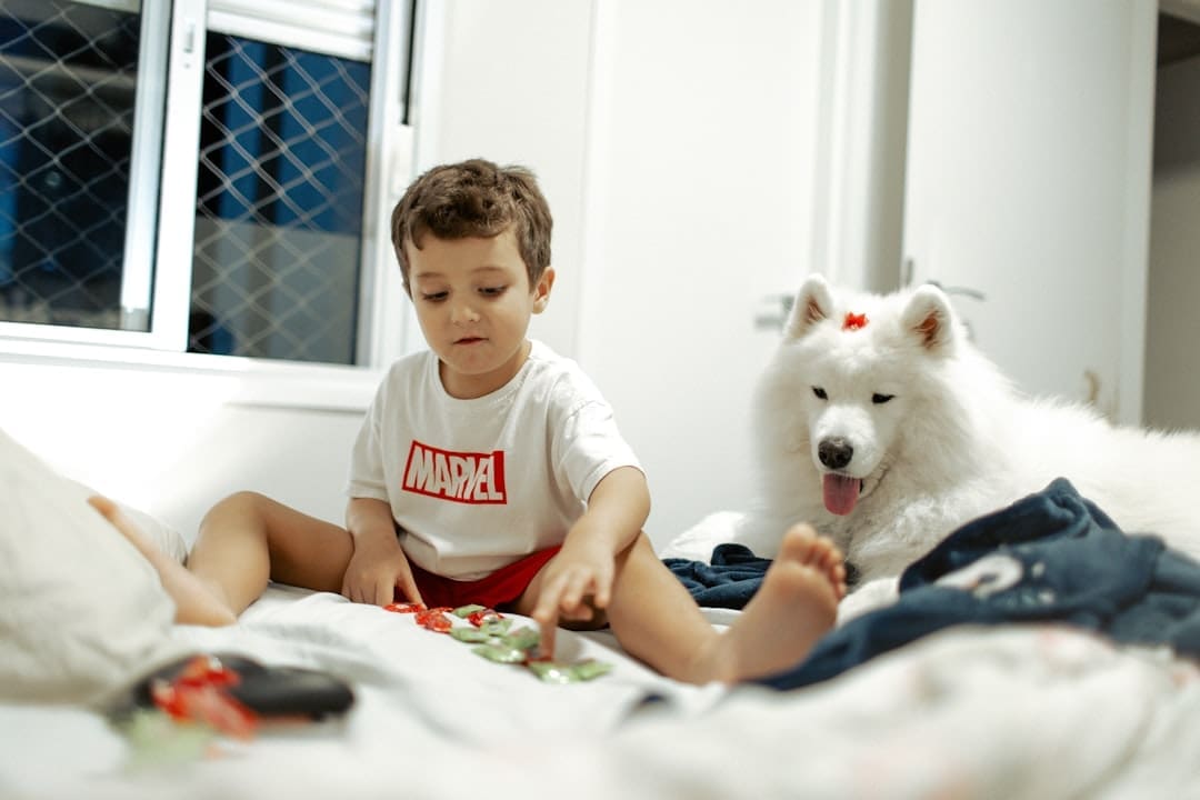 support animal denied — A young boy and a white dog on a bed