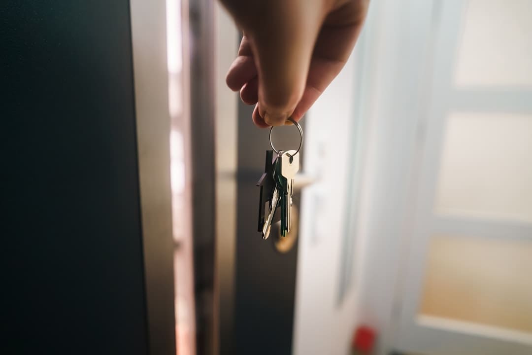 support animals condos — A hand holds a keyring near an open door.